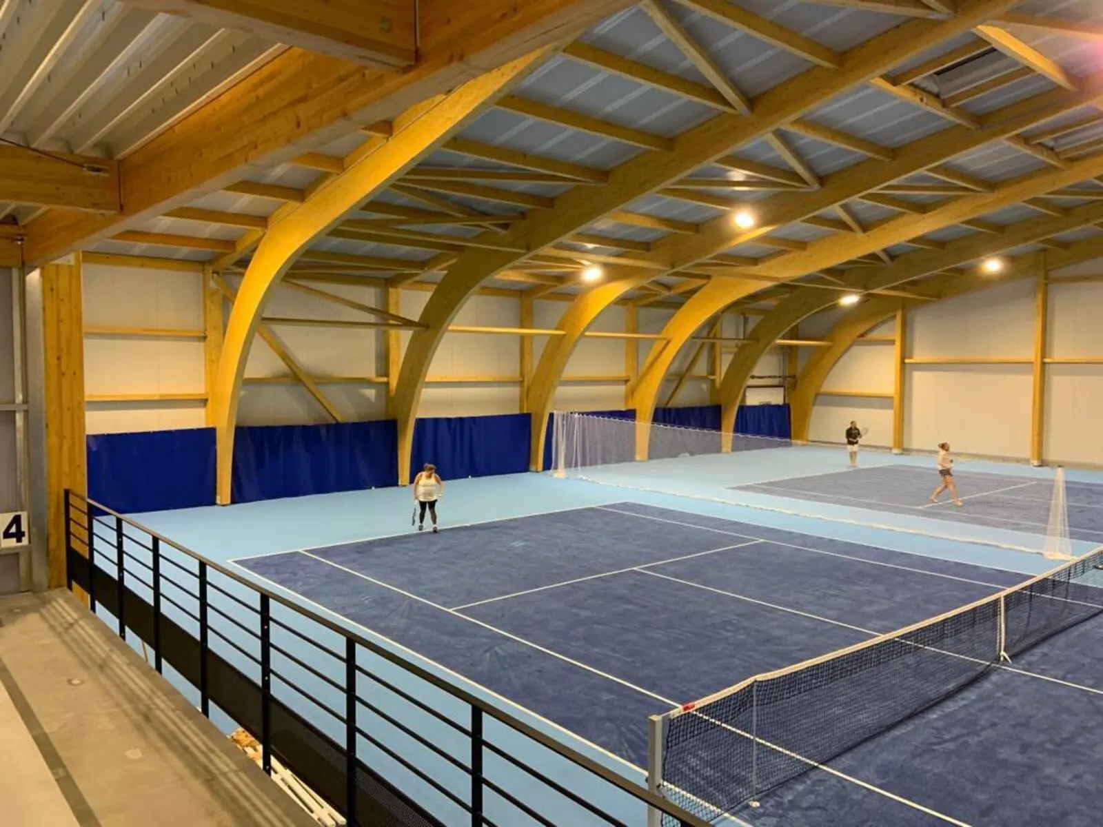 Match sur un court de tennis intérieur bénéficiant d’un éclairage LED optimal - Win4LED