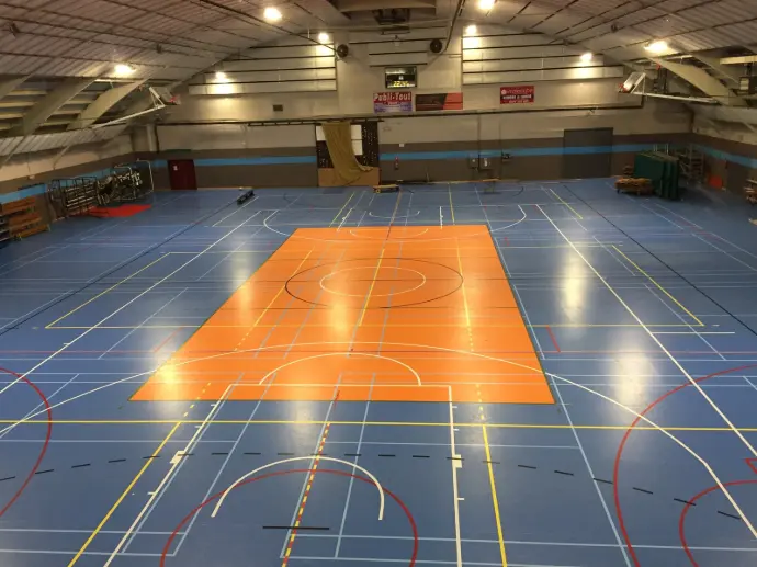 Éclairage LED performant dans un gymnase multisports – terrain de basketball bien éclairé
